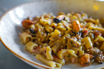 dish with handmade pasta with potatoes, cuttlefish, squid, squid, squid, red prawn and scampi in a luxurious Italian restaurant