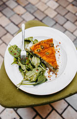 Opened pie with spinach and olives.