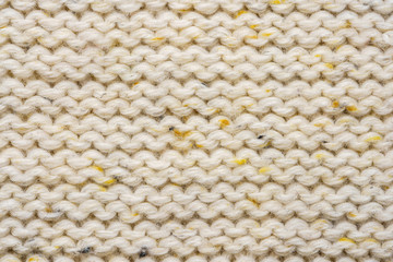 The texture of a knitted sweater. Beige pattern. Inside. Background. Copy space