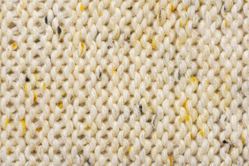 The texture of a knitted sweater. Beige pattern. Inside. Background. Copy space