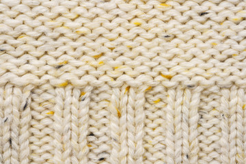 The texture of a knitted sweater. Beige pattern. Inside. Background. Copy space