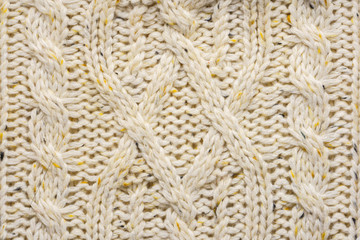 The texture of a knitted beige sweater. Beautiful textured arana patterns. Background. Copy space