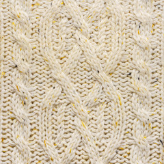 The texture of a knitted beige sweater. Beautiful textured arana patterns. Background. Copy space