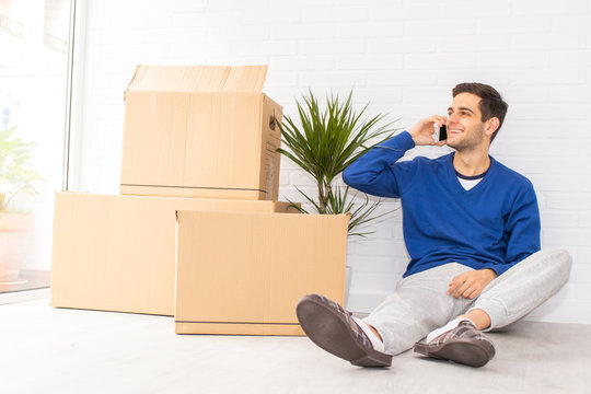 young man in the apartment with moving and mobile phone