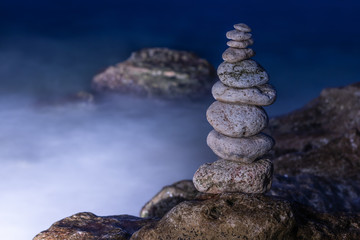 Object of stones on the background of the night sky and the  sea. Zen stones. Harmony & Meditation