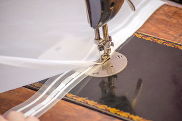 sewing on a sewing machine. white fabric on sewing machine