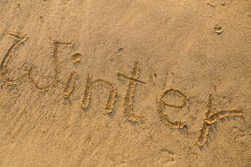 Fototapeta na wymiar Winter Schriftzug in den Sand geschrieben