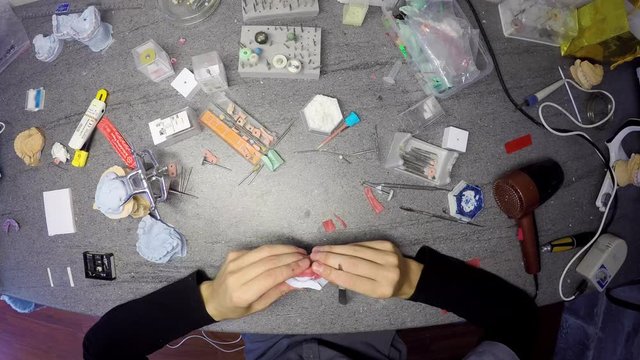 Timelapse from above of a table of dental technician making a model of jaws