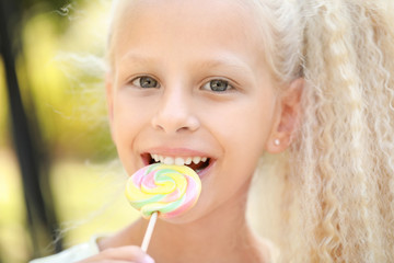 Cute little girl with lollipop outdoors