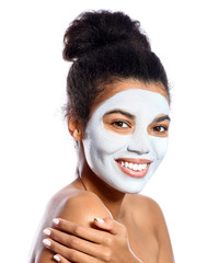 Beautiful African-American woman with facial mask on white background