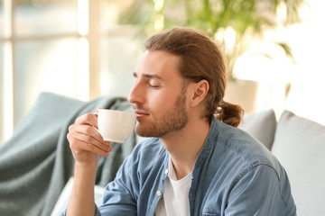 Handsome man drinking coffee at home