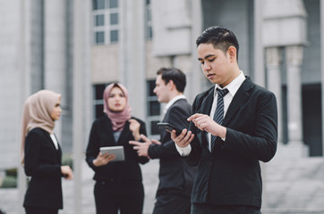 Portrait of young businessman Texting to Someone on his Mobile Phone with Happy Facial Expression.