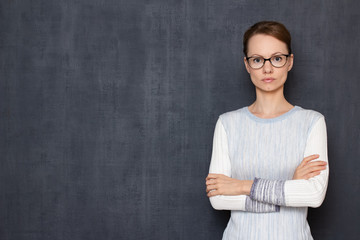 Portrait of serious focused girl holding arms crossed on chest