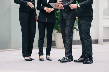unidentified image group of young executive people in formalwear holding tablet and discussing something
