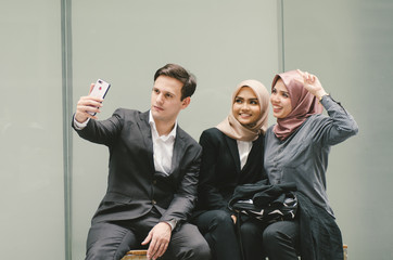 group of young businesswoman and businessman in black suit using a mobile phone and taking photo