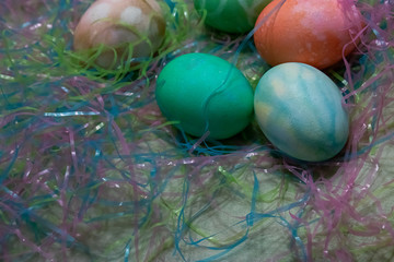 colorful dyed easter eggs gathered on a table with easter grass