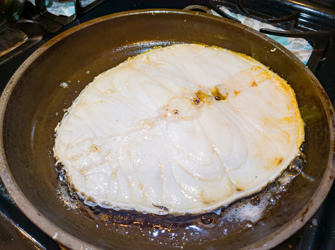 Frying a big Patagonian toothfish steak in a pan