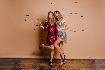 Full-length portrait of adorable european girls dancing together with happy laugh. Stunning female...