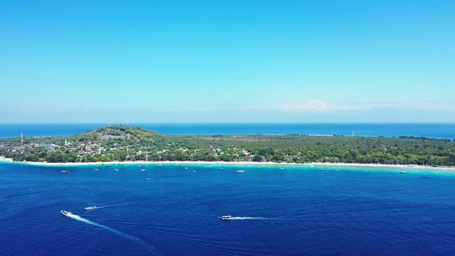 Paradise island in a tropical ocean, Bali, Indonesia, boats sailing in the blue waters