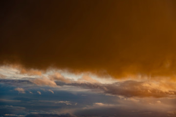 Fototapeta na wymiar Dramatic sunset light reflect in dark storm clouds.