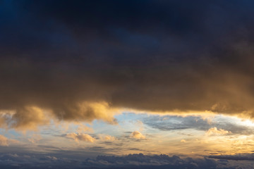 Naklejka na ściany i meble Dramatic sunset light reflect in dark storm clouds.