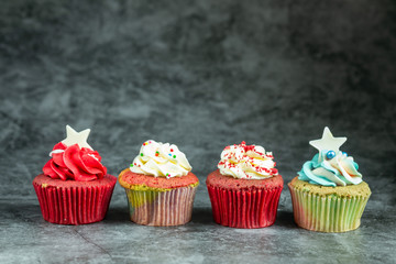 Many sweet colored cupcakes for birthdays, Merry Christmas and New Year 2020 on cement background.