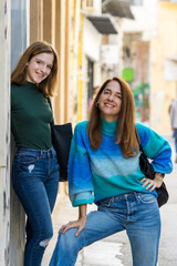 Portrait of a happy mother and teenage daughter, outdoors, urban style.