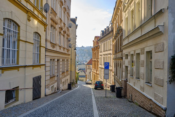 Fototapeta na wymiar Scenic view of narrow street of Karlovy Vary - small ancient touristic resort town near the border between Czech Republic and Germany. Beautiful summer sunny look of famous town among hills in Czechia