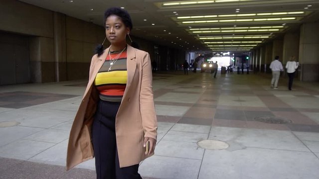 Chicago,IL/USA October 9th 2019: African american black woman  tourist with Afro is walking in slow motion. wearing business casual clothes in the heart of downtown big city 