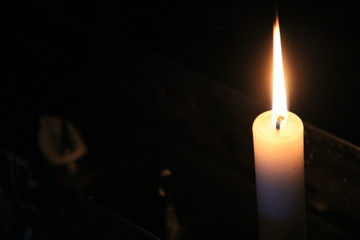 暗闇で灯されるロウソク