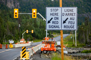 selective focus on a white road sign on Wooden pole, road work zone with Machines in the...