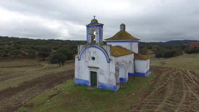 Small old chapel in the middle of cork oaks forest field aerial shot 4k