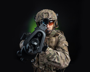 a male soldier in military clothes with a weapon on a dark background