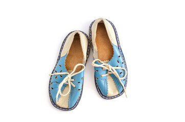 A pair of leather, children's old-fashioned shoes on a light, white background. Vintage sandals