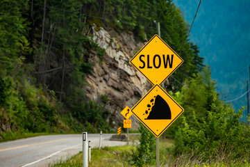 slow, Watch for fallen rock and be prepared to avoid a collision, Warning yellow roads signs in...