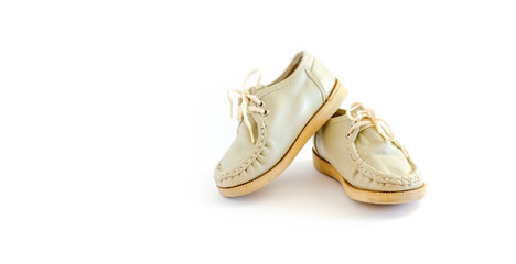 A pair of leather, children's old-fashioned shoes on a light, white background. Vintage boots