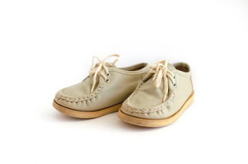A pair of leather, children's old-fashioned shoes on a light, white background. Vintage boots