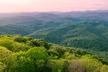 Obraz premium Layers of mountains in the haze during sunset. Beautiful sunset in the mountains. Beautiful sunset in a hilly valley with villages and fog in the lowlands.
