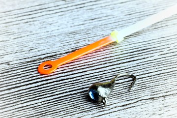 Winter fishing lure on the grey wooden table