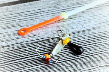 Winter fishing lure on the grey wooden table