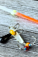 Winter fishing lure on the grey wooden table