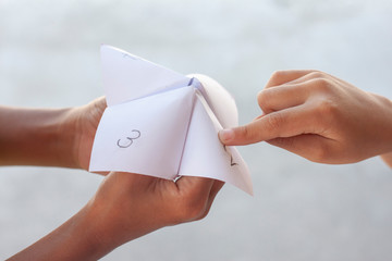 Children play fun paper fortune tellers games. - obrazy, fototapety, plakaty