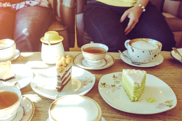 Happiness female friends meeting and drinking tea or coffee with cakes together at cafe in the afternoon. People, leisure and communication concept. Selective focus.