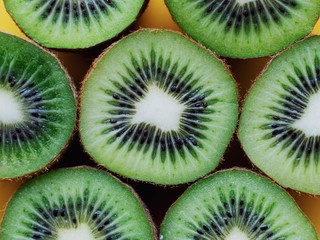 slices of kiwi on yellow background.  kiwi isolated on YELLOW background. fruits in advertising