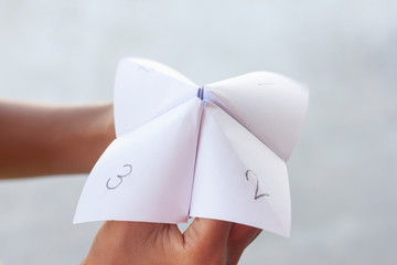 Children play fun paper fortune tellers games.