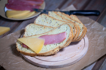 Meat, cheese and bread on a wooden background