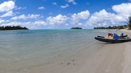 twin hulled leisure boats sitting on the beach at Tropical Muri beach lagoon on a hot sunny day