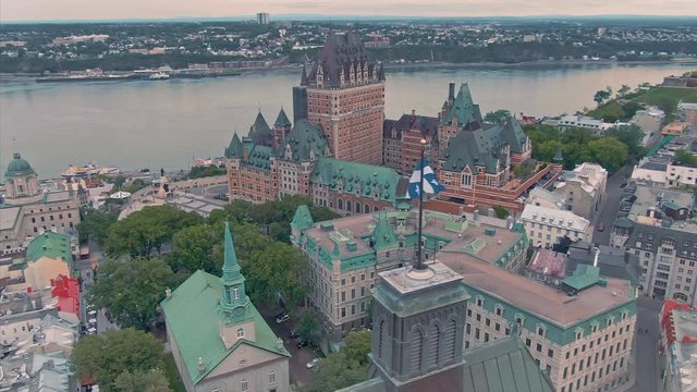 Aerial flying around the Ch&acirc;teau Frontenac in old Quebec City with the quebec flag in the foreground, Quebec, Canada 3 september 2019