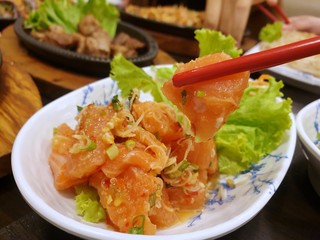 Japanese food style, Selective focus of chopsticks holding salmon salad, Salmon sashimi is Japanese traditional, Selective focus