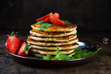 Classic American Breakfast pancake with honey and berries. Still life of lush pancakes, honey and strawberries.